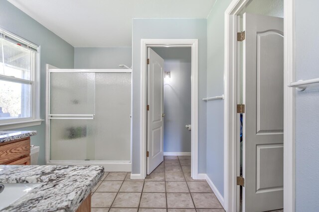 bathroom with tile patterned floors, walk in shower, and vanity