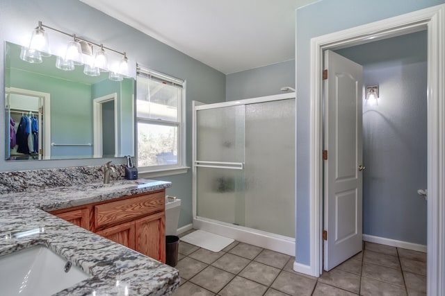 bathroom with tile patterned flooring, a shower with shower door, and vanity