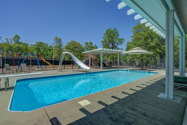 view of swimming pool featuring a water slide and a playground