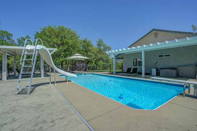 view of swimming pool with a water slide and a patio area