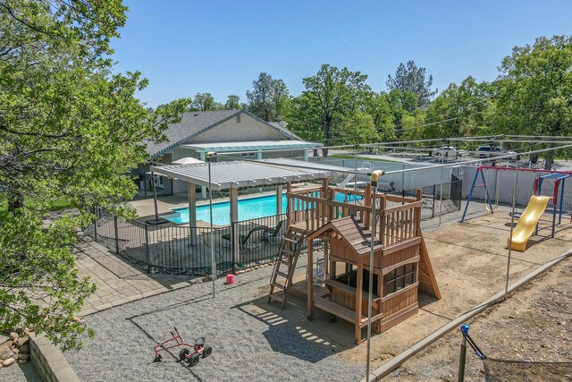 view of swimming pool with a playground and a patio