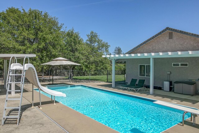 view of pool with a water slide and a patio area