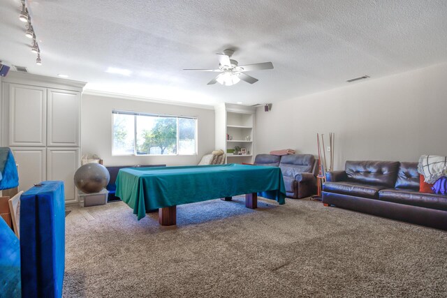 rec room with a textured ceiling, carpet, ceiling fan, and track lighting