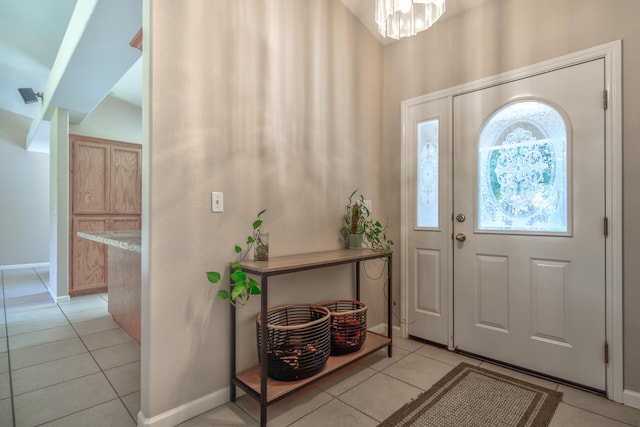 tiled entryway with an inviting chandelier