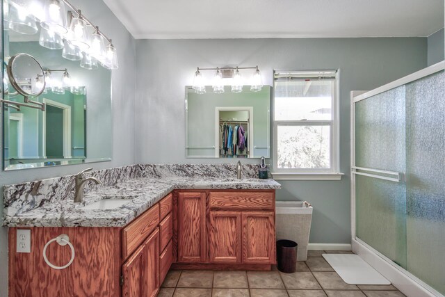 bathroom featuring tile patterned flooring, an enclosed shower, and vanity