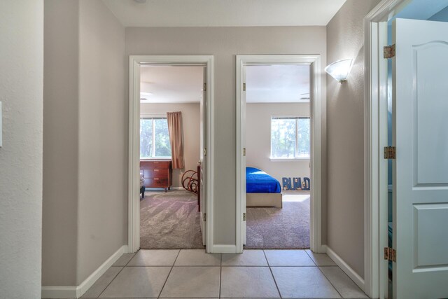 hallway featuring light colored carpet and a healthy amount of sunlight