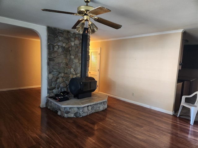 living room featuring a wood stove, ceiling fan, dark hardwood / wood-style floors, and ornamental molding