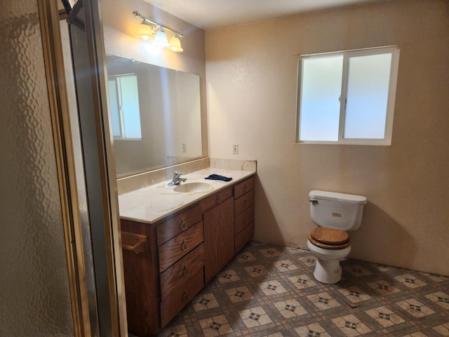 bathroom featuring a wealth of natural light, vanity, and toilet