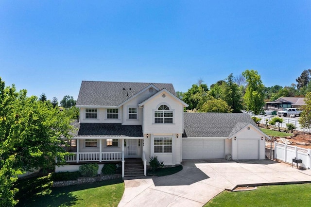 view of front of property with a garage, covered porch, and a front yard