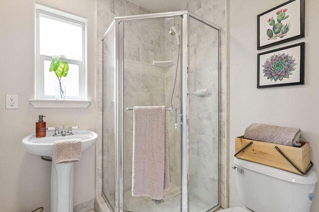 bathroom with toilet and a shower with shower door