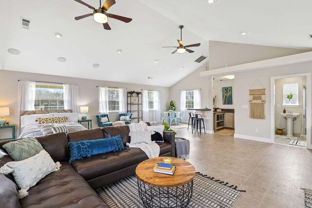 living room with high vaulted ceiling, light tile patterned floors, and ceiling fan