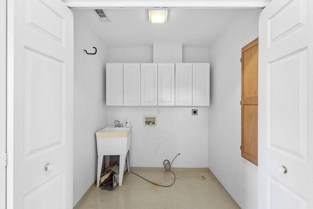 washroom with hookup for a washing machine, cabinets, and electric dryer hookup