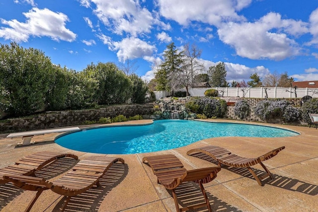 view of swimming pool with a patio area and a diving board