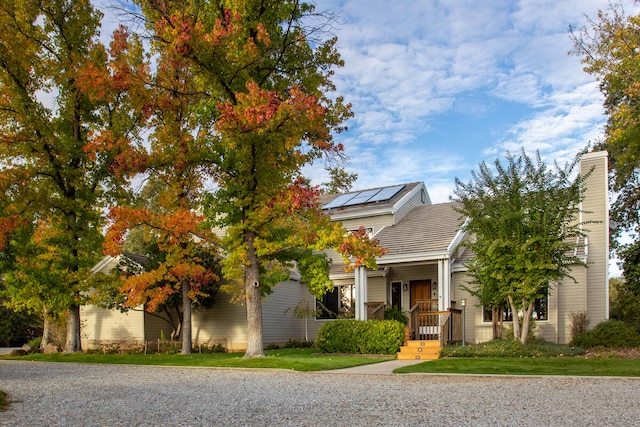 view of property hidden behind natural elements featuring a front yard