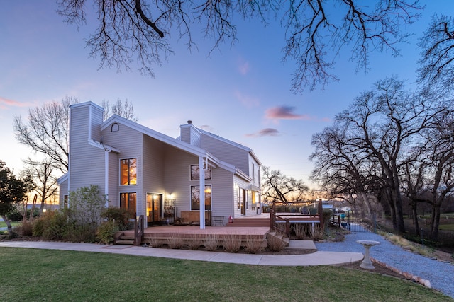 back house at dusk featuring a yard