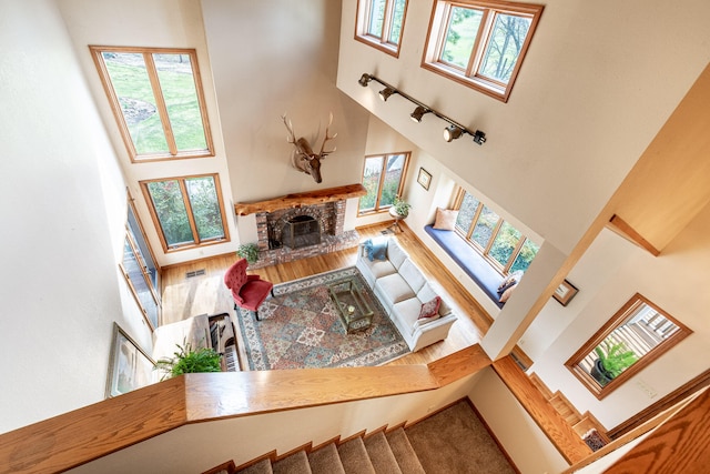 living room featuring a brick fireplace and a high ceiling