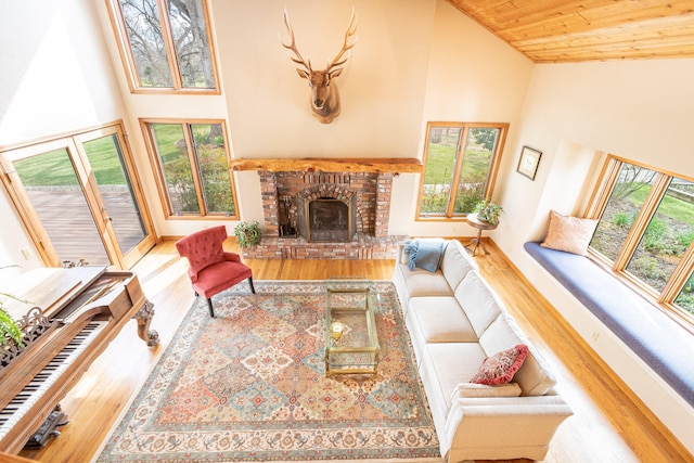 living room with a wealth of natural light, a brick fireplace, high vaulted ceiling, and wood ceiling