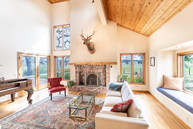 living room with beamed ceiling, a fireplace, light hardwood / wood-style flooring, wood ceiling, and high vaulted ceiling