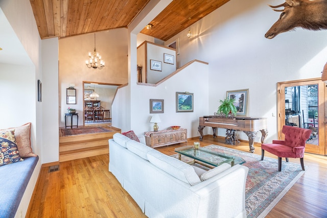 living room with wooden ceiling, high vaulted ceiling, an inviting chandelier, and light hardwood / wood-style floors