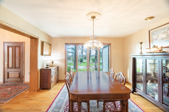 dining room featuring plenty of natural light, light hardwood / wood-style flooring, and an inviting chandelier