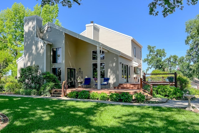 back of property with a lawn and a deck