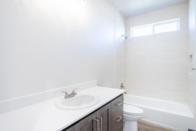 full bathroom featuring vanity, hardwood / wood-style floors, toilet, and washtub / shower combination