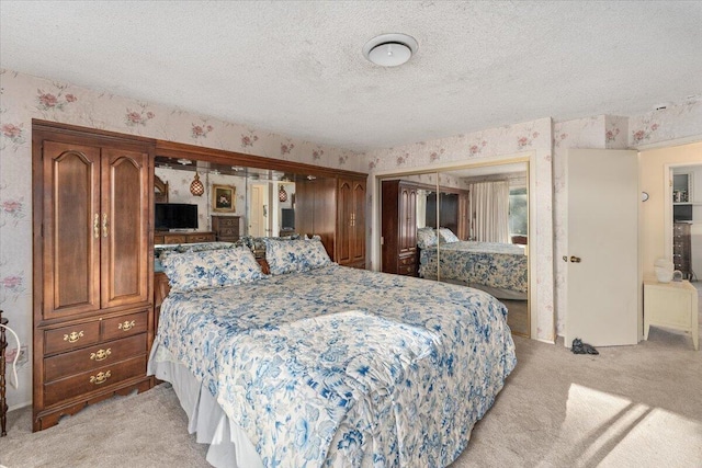 bedroom featuring a closet, light carpet, and a textured ceiling