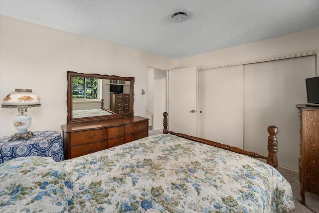 bedroom with a textured ceiling, carpet, and a closet