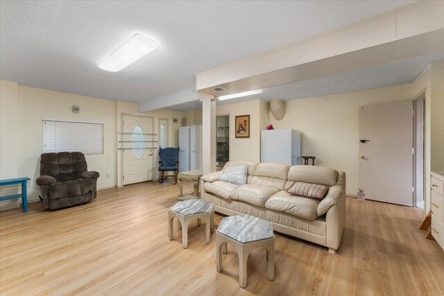 living room featuring a textured ceiling and light wood-type flooring