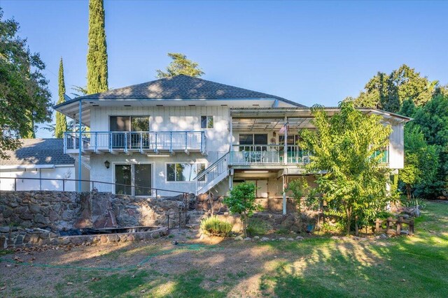 back of house with a yard and a balcony