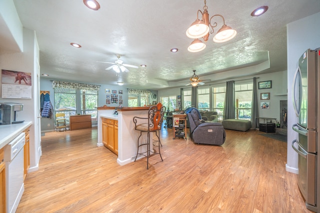 kitchen with stainless steel fridge, a textured ceiling, dishwasher, ceiling fan with notable chandelier, and light hardwood / wood-style floors