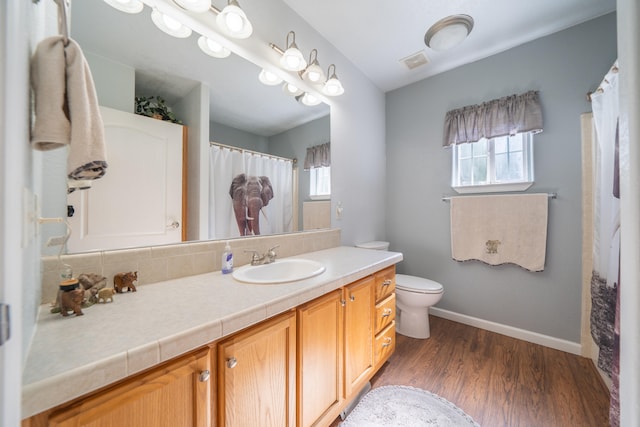 bathroom featuring vanity, toilet, and hardwood / wood-style flooring