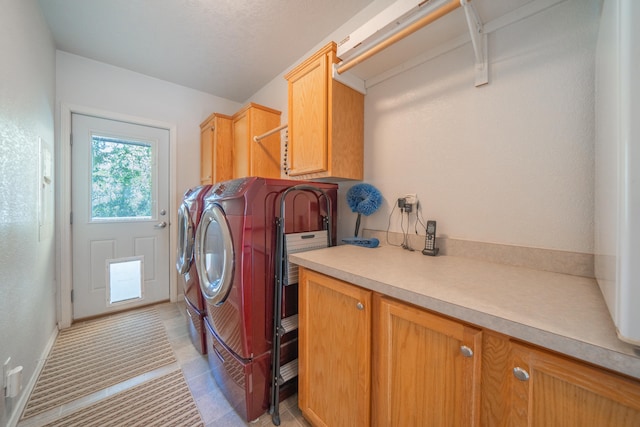 laundry room featuring cabinets and washing machine and clothes dryer