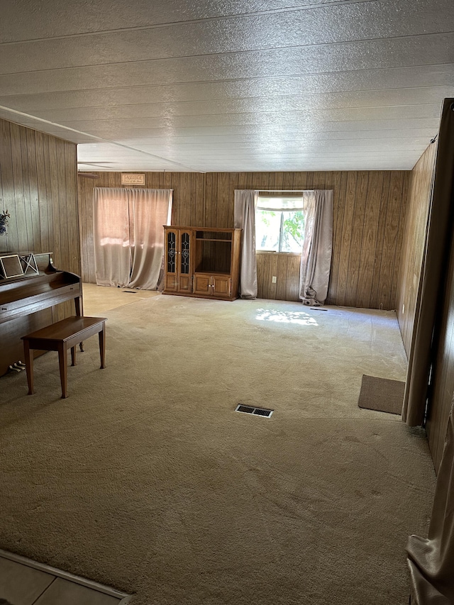 unfurnished living room with carpet flooring and wood walls