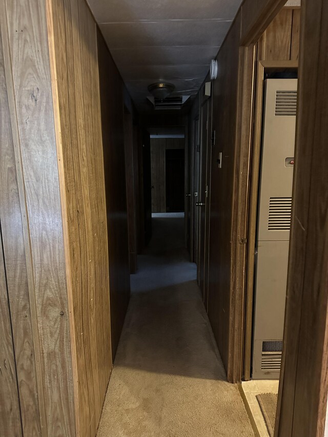 corridor with light colored carpet and wooden walls