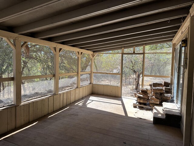 unfurnished sunroom featuring vaulted ceiling