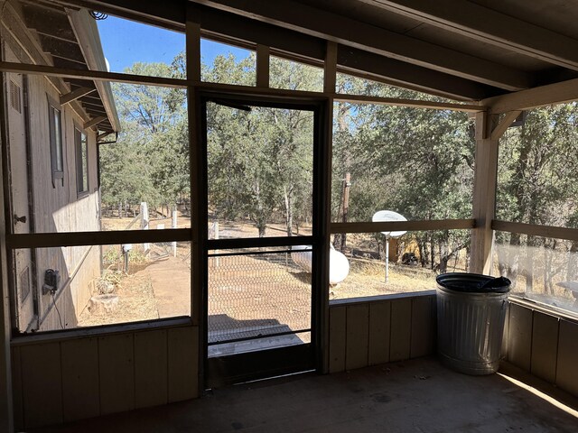 unfurnished sunroom featuring plenty of natural light and vaulted ceiling