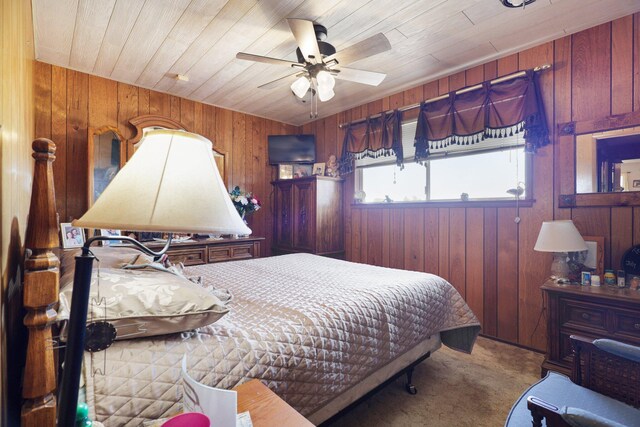 carpeted bedroom featuring ceiling fan, wood ceiling, and wooden walls