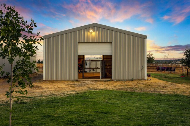 outdoor structure at dusk featuring a yard