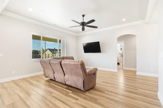 living room featuring light wood-type flooring, ornamental molding, and ceiling fan