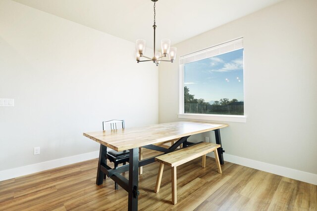 dining space featuring a notable chandelier and light wood-type flooring