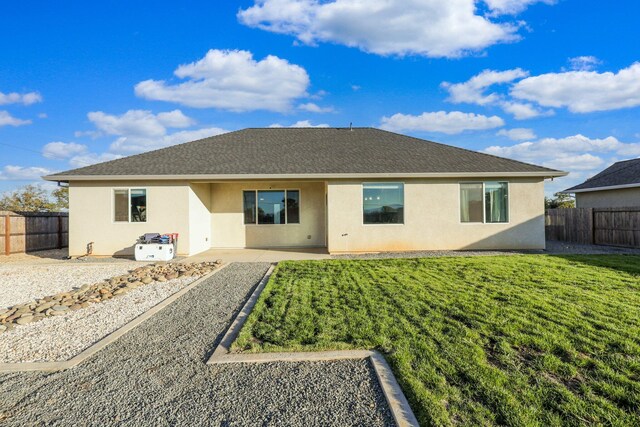 back of house featuring a lawn and a patio