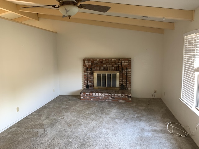 unfurnished living room with a ceiling fan, visible vents, carpet floors, vaulted ceiling with beams, and a brick fireplace