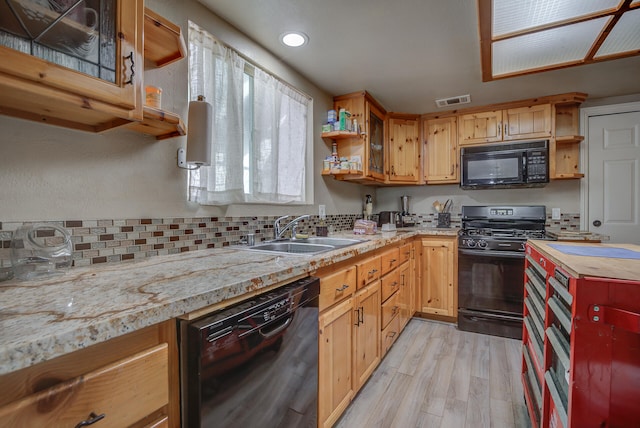 kitchen featuring black appliances, backsplash, sink, and light hardwood / wood-style floors