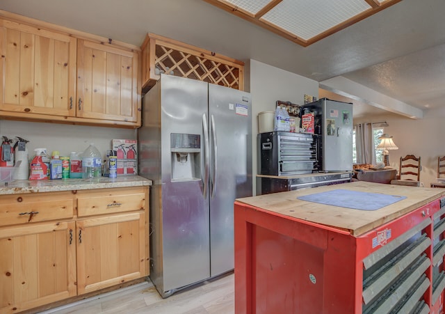 kitchen with wood counters, light wood-type flooring, stainless steel fridge with ice dispenser, and light brown cabinets