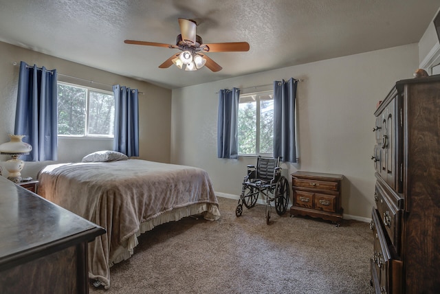 carpeted bedroom featuring multiple windows, a textured ceiling, and ceiling fan