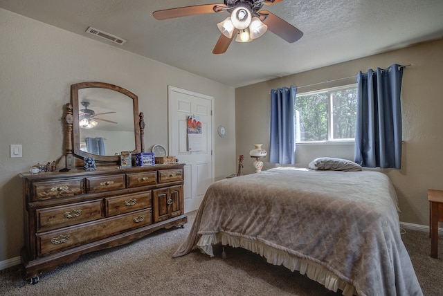 carpeted bedroom with ceiling fan and a textured ceiling