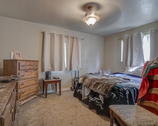 carpeted bedroom with ceiling fan and a textured ceiling