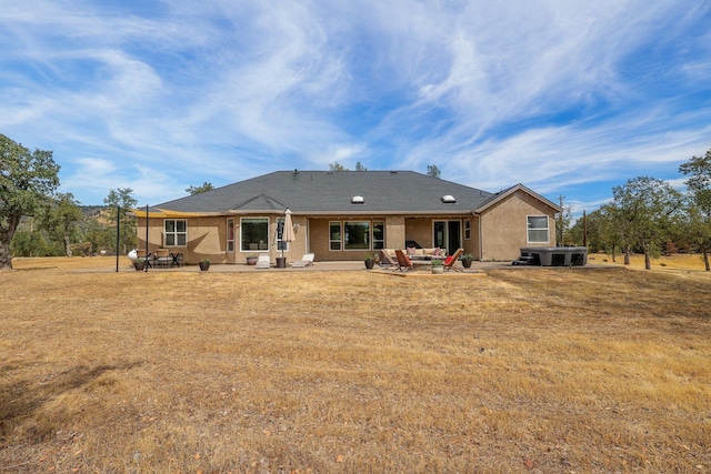 back of property featuring a patio area and a lawn