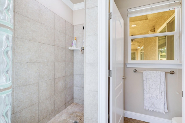 bathroom with a tile shower and toilet